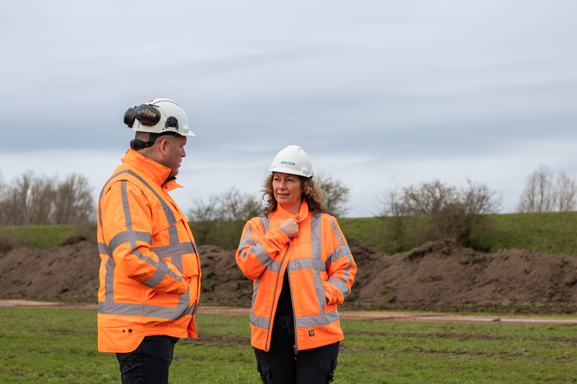 Foto van twee Ploegam-medewerkers in oranje hesjes.